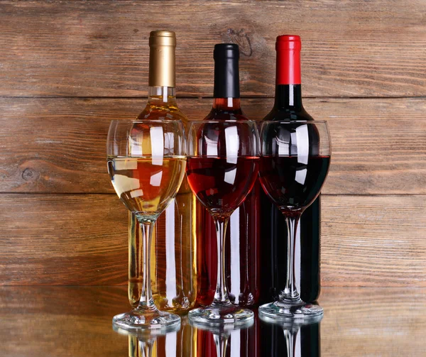 Different wine on table on wooden background — Stock Photo, Image