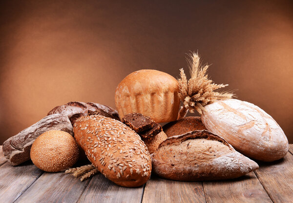 Different bread on table on brown background