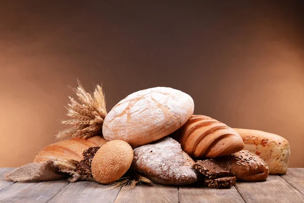 Pan diferente en la mesa sobre fondo marrón —  Fotos de Stock
