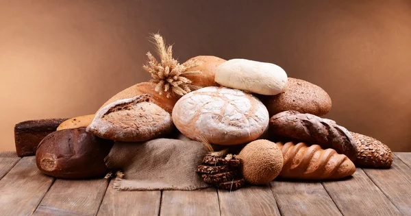 Pane diverso sul tavolo su sfondo marrone — Foto Stock