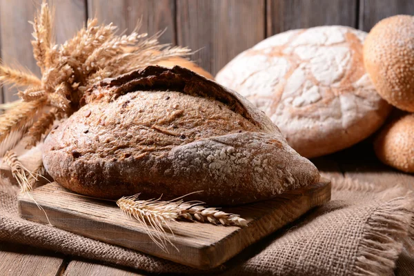 Smaczny chleb na stole na drewniane tła — Zdjęcie stockowe