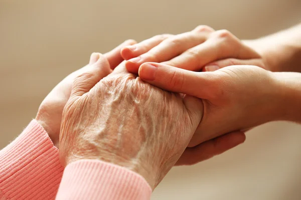 Old and young holding hands Stock Image