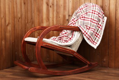 Sallanan sandalye ahşap duvar arka plan üzerinde ekose kaplı