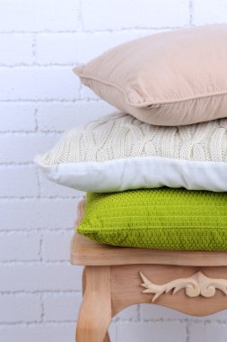 Yastıklar küçük ahşap masa ve beyaz tuğla duvar arka plan