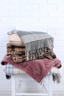 Sıcak ekoseler ve yastığın beyaz tuğla duvar arka plan üzerinde