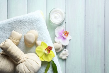 Ahşap masa arka plan üzerinde orkide çiçekleri ile spa uygulamaları