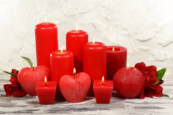 Hermosas velas con flores en la mesa sobre fondo gris —  Fotos de Stock