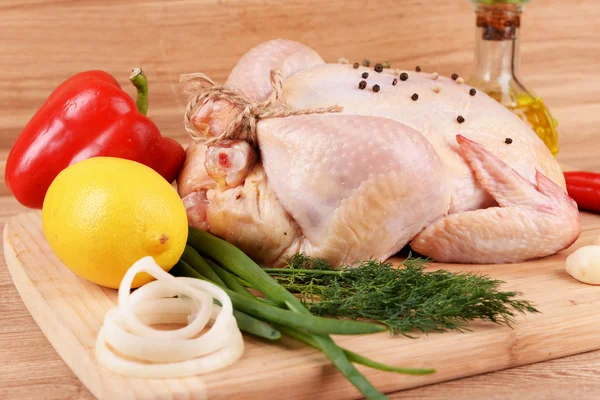 Raw chicken on wooden table — Stock Photo, Image