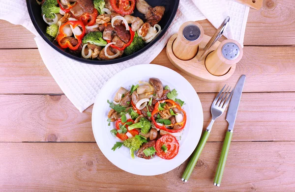 Funghi selvatici brasati con verdure e spezie in padella e piatto sul tavolo — Foto Stock