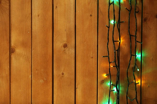 Luci di Natale ghirlanda su sfondo di legno — Foto Stock