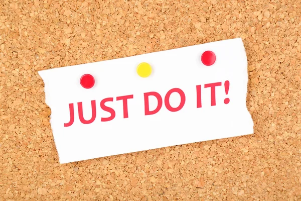 Motiveren papier blad met inscriptie "Just do it" op houten achtergrond — Stockfoto