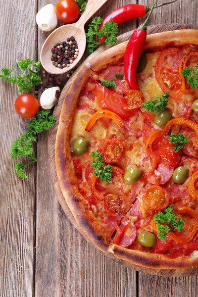 Pizza saborosa com especiarias e colher em fundo de mesa de madeira — Fotografia de Stock