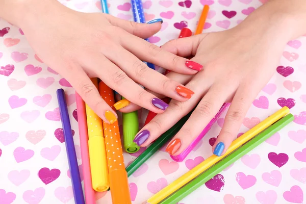 Manicure femminile multicolore con pennarelli e matite su sfondo brillante — Foto Stock
