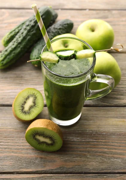 Зеленый свежий здоровый сок с фруктами и овощами на фоне деревянного стола — стоковое фото