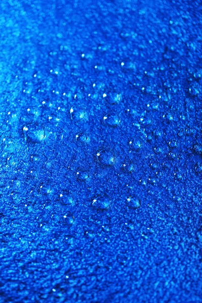 Gocce d'acqua sullo sfondo della superficie di colore, vista macro — Foto Stock