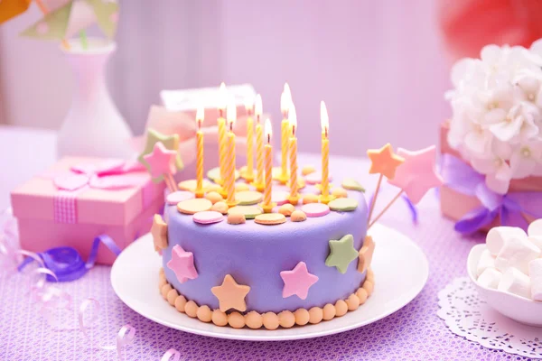 Delicioso bolo de aniversário na mesa no fundo brilhante — Fotografia de Stock