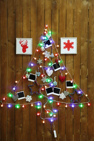 Guirnalda en forma de árbol de Navidad sobre fondo de pared de madera — Foto de Stock