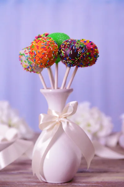 Sweet cake pops in vase on table on light background — Stock Photo, Image