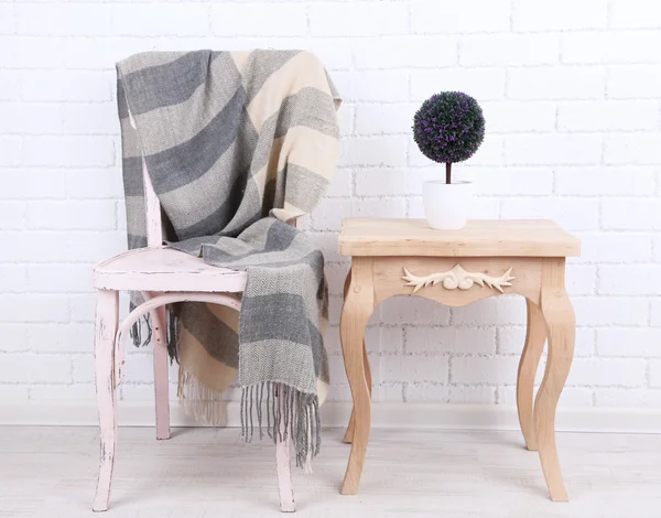 Intérieur moderne avec chaise et plaid sur elle sur fond de mur de brique blanche — Photo