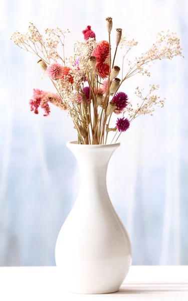 Bukett av torkade blommor i vas på ljus bakgrund — Stockfoto