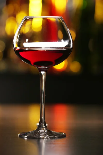 Sklenka vína s barem na pozadí — Stock fotografie