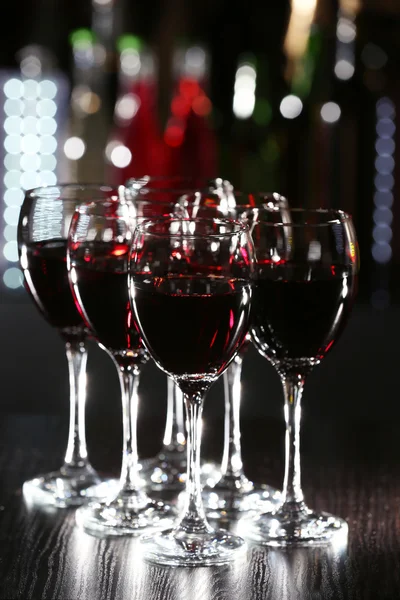 Glasses of wine with bar on background — Stock Photo, Image