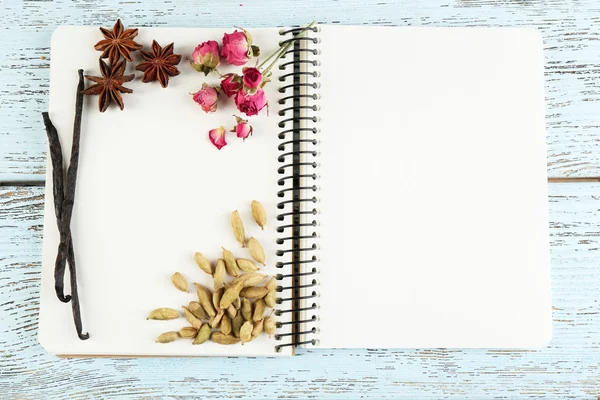 Épices avec livre de recettes sur fond de table en bois couleur — Photo