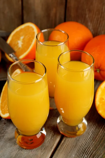 Copo de suco de laranja com fatias no fundo da mesa de madeira rústica — Fotografia de Stock