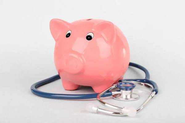 Pink piggy bank with stethoscope isolated on white — Stock Photo, Image