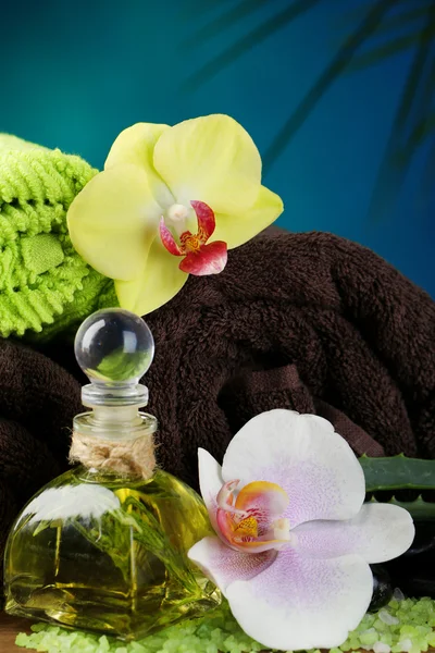 Wellness-Behandlungen mit Orchideenblumen auf Holztisch vor buntem Hintergrund — Stockfoto