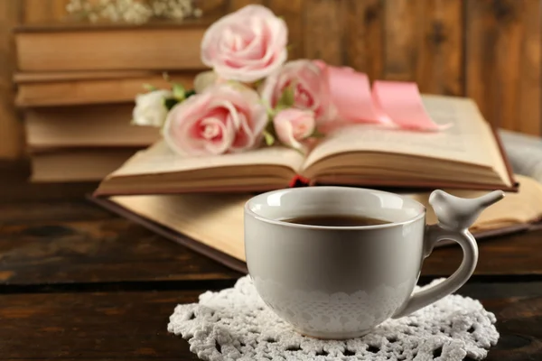 लकड़ी की पृष्ठभूमि पर किताबों और फूलों के साथ चाय का कप — स्टॉक फ़ोटो, इमेज