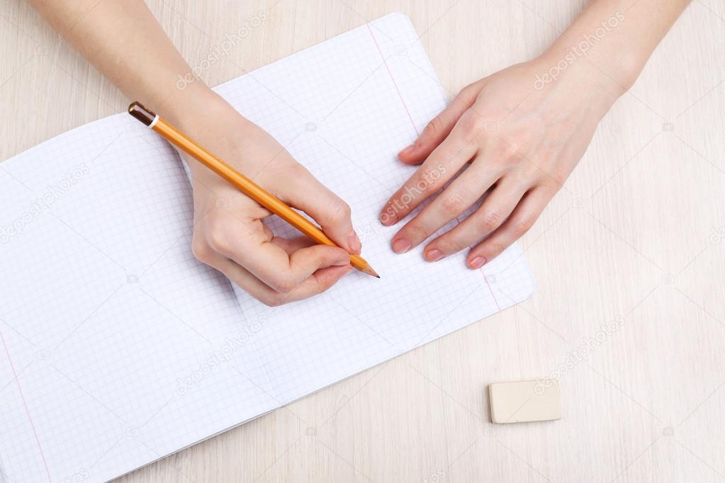 Hands with pencil writing on paper