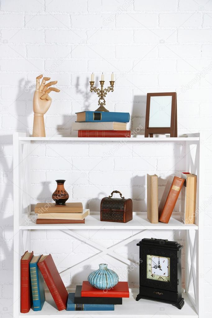 Boekenkasten met boeken en decoratieve objecten op bakstenen muur ... Boekenkasten met boeken en decoratieve objecten op bakstenen muur ...