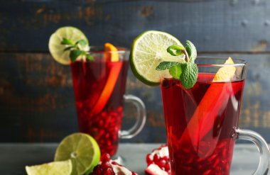 Nar İçecek gözlük nane ve portakal ve renk ahşap arka plan üzerinde limon dilimleri ile