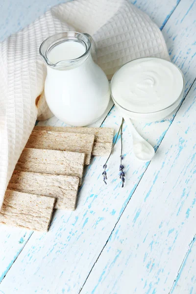 Домашний йогурт и вкусный хрустящий хлеб на фоне деревянного стола — стоковое фото