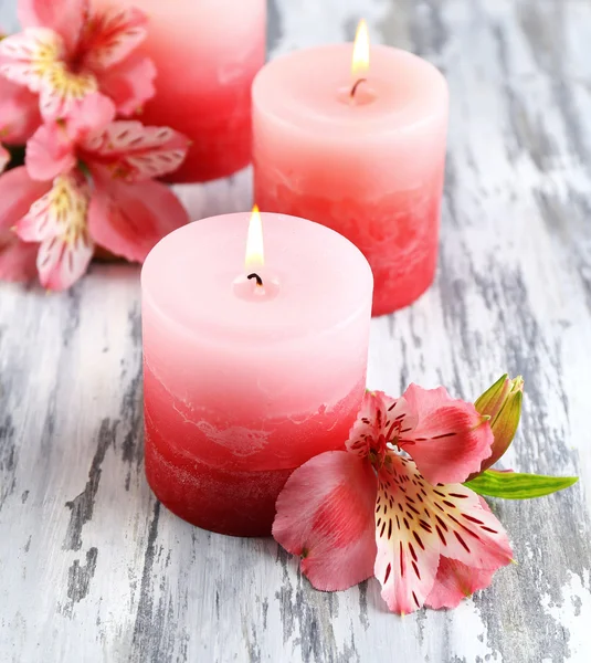 Hermosas velas con flores sobre fondo de madera — Foto de Stock