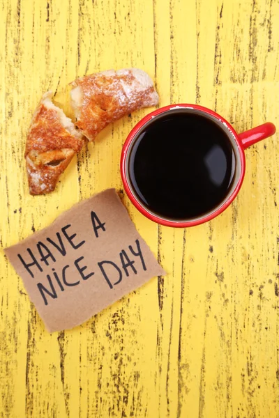 Composizione di caffè, croissant fresco e cartoncino su fondo legno — Foto Stock