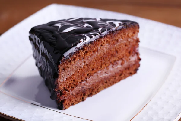 Delicioso bolo de chocolate no prato na mesa close-up — Fotografia de Stock