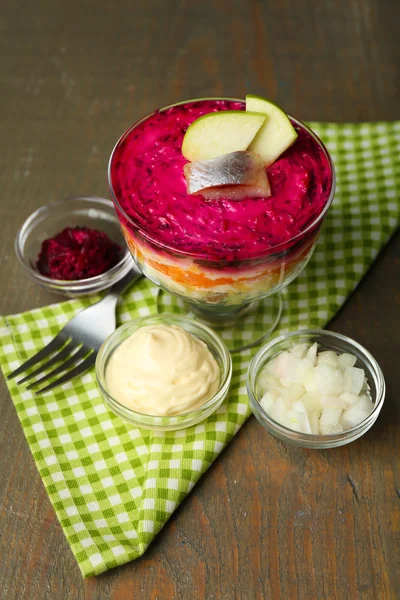 Russian herring salad in glass bowl on wooden table background — Stock Photo, Image