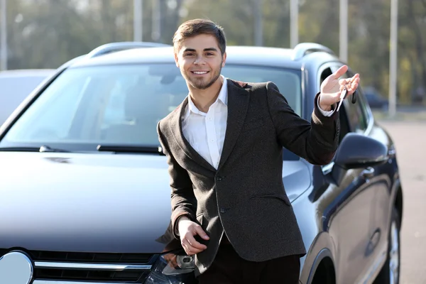Бизнесмен держит ключи от машины на улице — стоковое фото