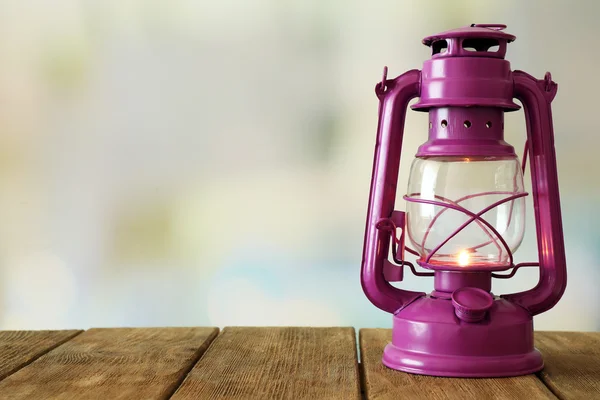 Oil lamp on wooden surface and blurred background — Stock Photo, Image