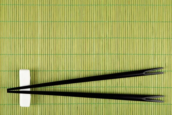 Pair of chopsticks on green bamboo mat background — Stock Photo, Image