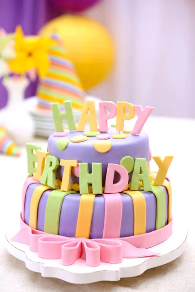 Delicioso bolo de aniversário na mesa no fundo brilhante — Fotografia de Stock