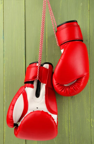 Par de guantes de boxeo sobre fondo de madera de color — Foto de Stock