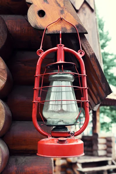 Kerosene lamp hanging on wooden house, outdoors — Stock Photo, Image