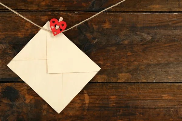 Love letter hanging on rope on rustic wooden background — Stock Photo, Image