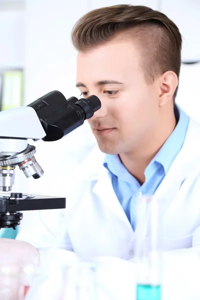 Mannelijke wetenschapper met behulp van microscoop in laboratorium — Stockfoto