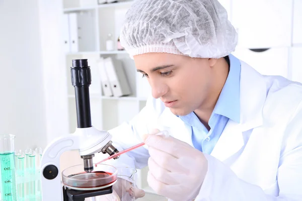Mężczyzna naukowiec stosujący mikroskop w laboratorium — Zdjęcie stockowe