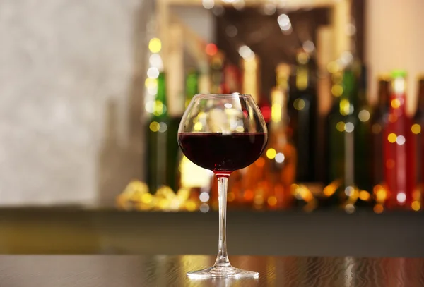 Kieliszek czerwonego wina w barze na tło zamazane pole — Zdjęcie stockowe