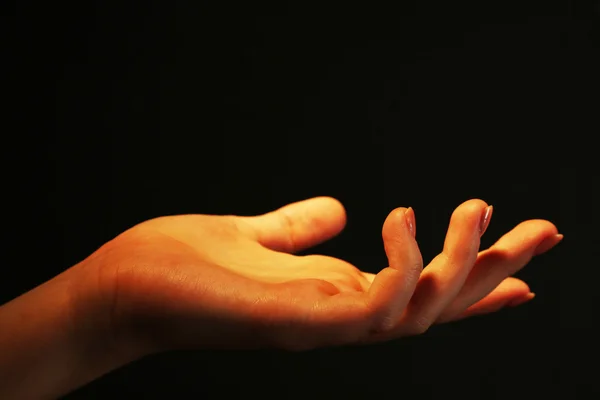 Ženská ruka na tmavém pozadí — Stock fotografie
